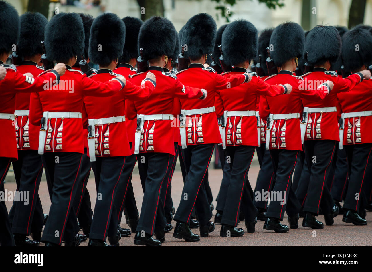 Soldati nel classico rosso cappotti marzo lungo il Mall a Londra in Inghilterra in un grand Trooping il colore spettacolo della Regina della Guardia Reale Foto Stock