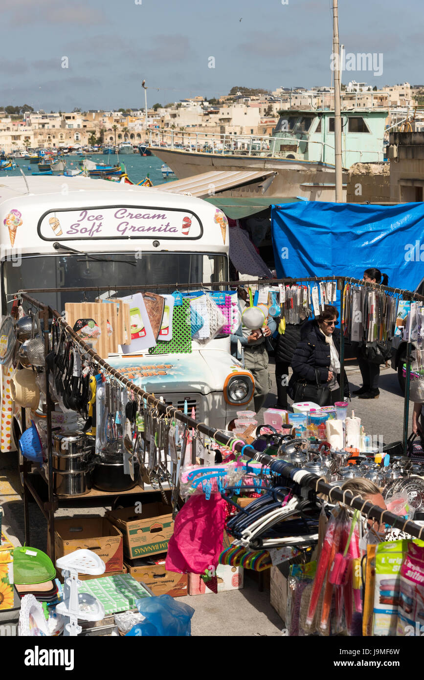 Una vista del mercato al porto di Marsaxlokk Malta con bancarelle che vendono vestiti Foto stock - Alamy