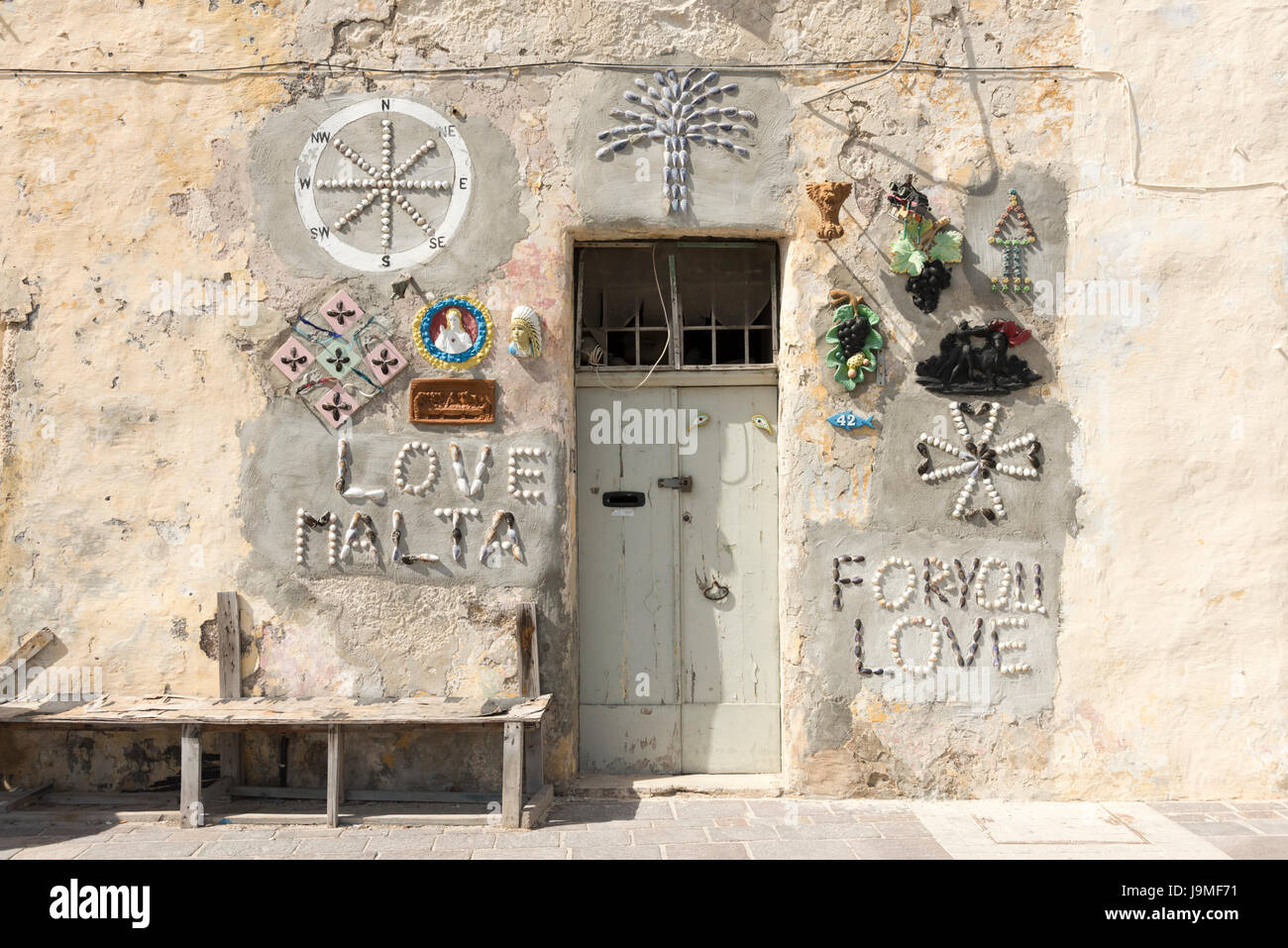 Una porta di una casa in Malta con amore di Malta e la shell di decorazioni su intonaco della parete Foto Stock