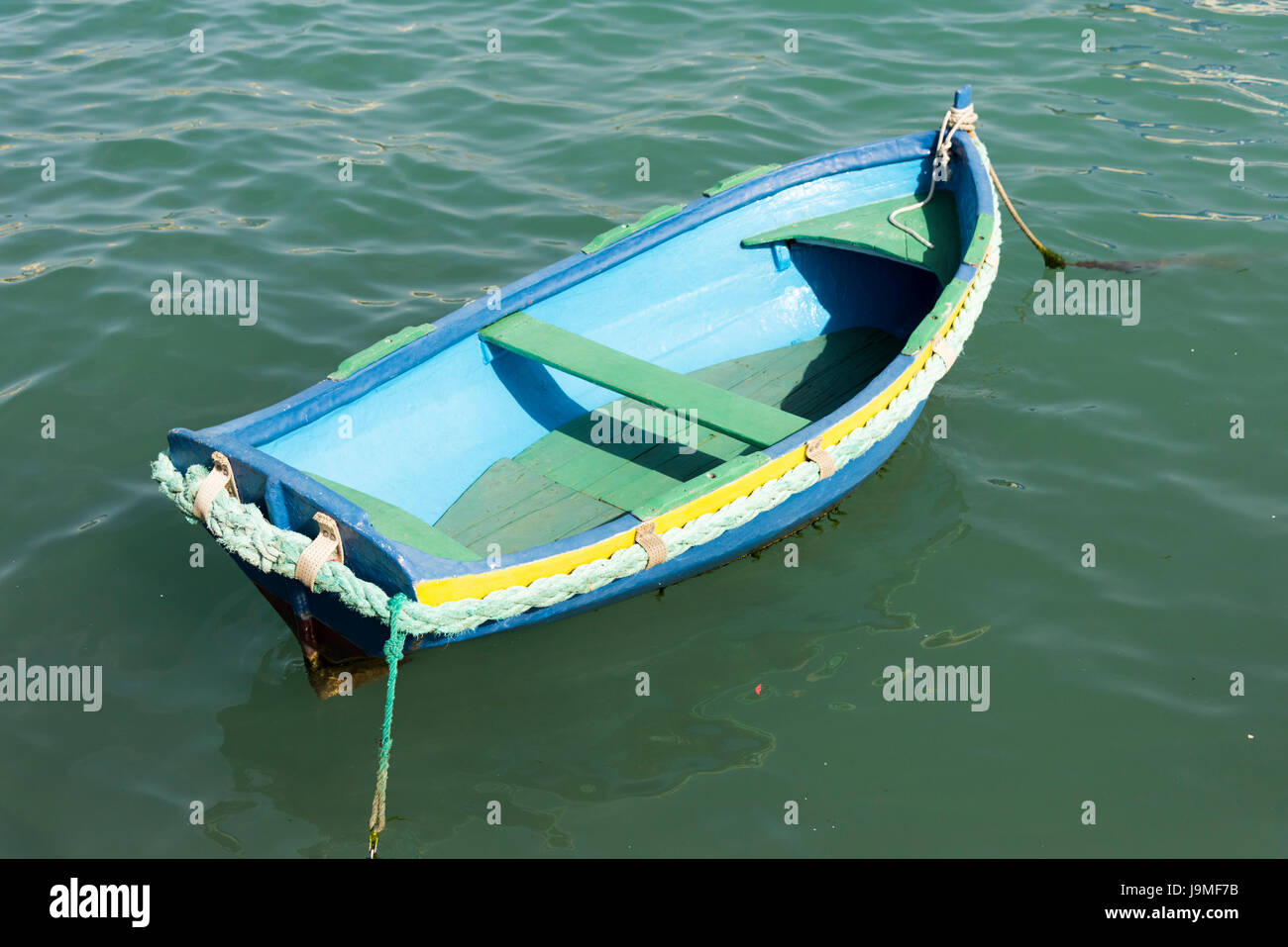 Una luminosa blu dipinto di piccole casette di legno a remi in barca al porto di Marsaxlokk Malta Foto Stock