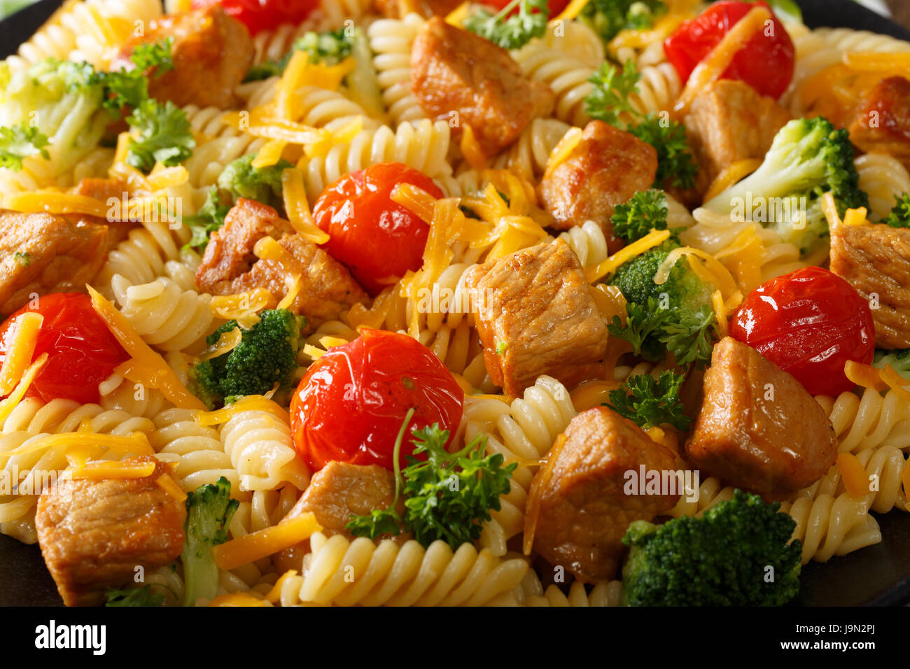 Bellissima cibo: fusilli con carne di maiale, broccoli, formaggio e pomodoro close up orizzontale. Foto Stock