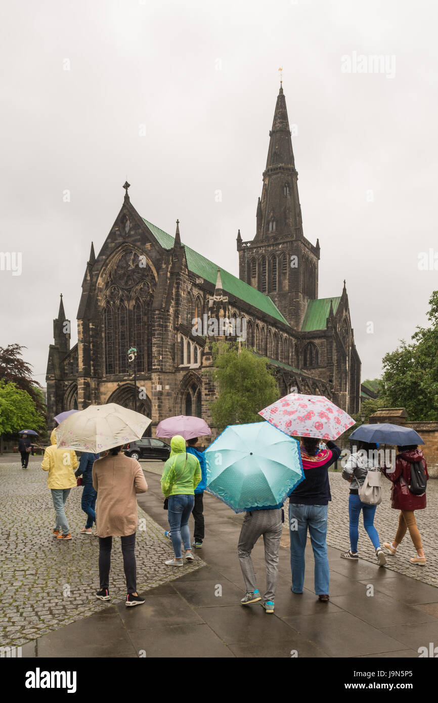 La cattedrale di Glasgow - turisti asiatici sotto la pioggia, Glasgow, Scotland, Regno Unito Foto Stock