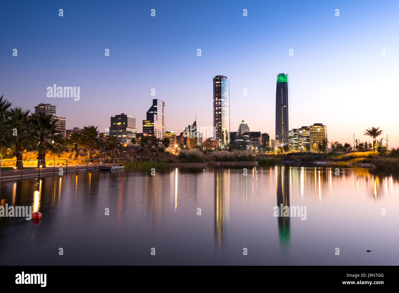 Laghetto presso il Parco del Bicentenario nel benestante quartiere Vitacura e sullo skyline di edifici al quartiere finanziario di Santiago del Cile Foto Stock