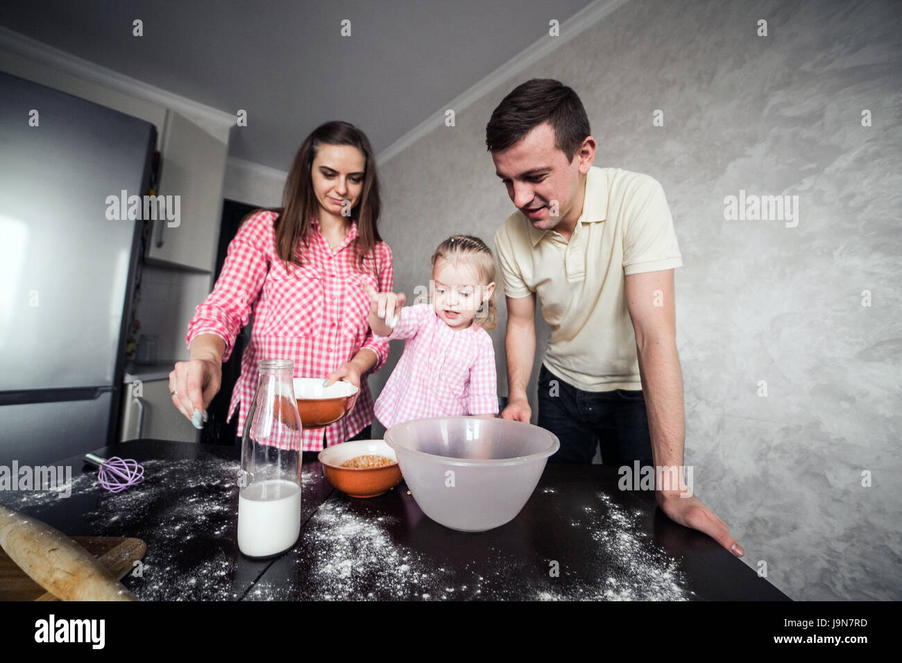 Papà, mamma e figlia insieme in cucina Foto Stock