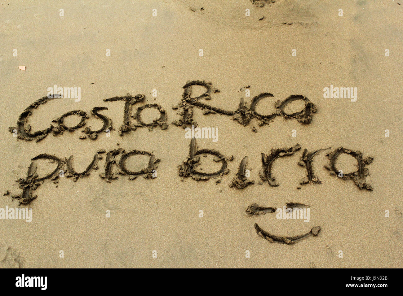 La scrittura in una spiaggia della Costa Rica, che dice 'pura birra" che simula il locale dicendo "Pura Vida". Foto Stock