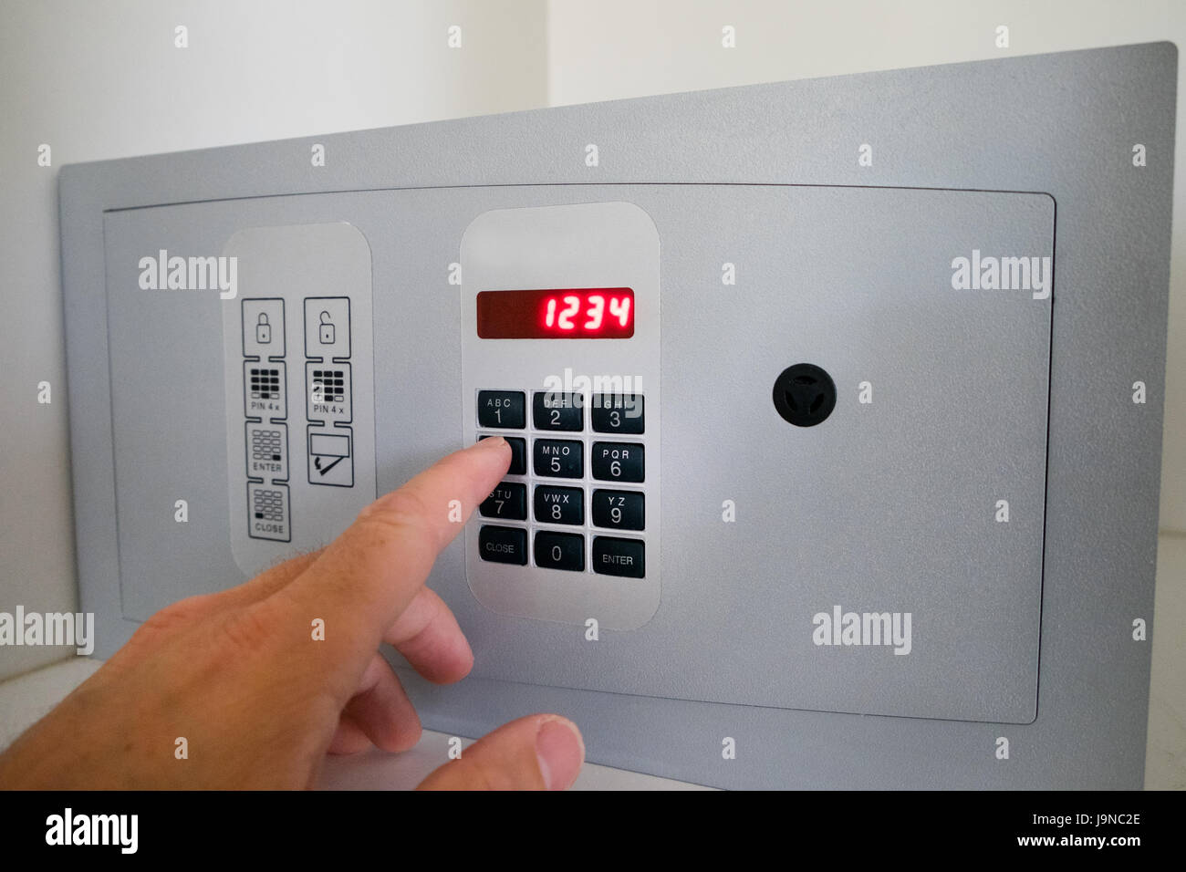 Un uomo che utilizza una cassetta di sicurezza nella stanza di albergo Foto Stock