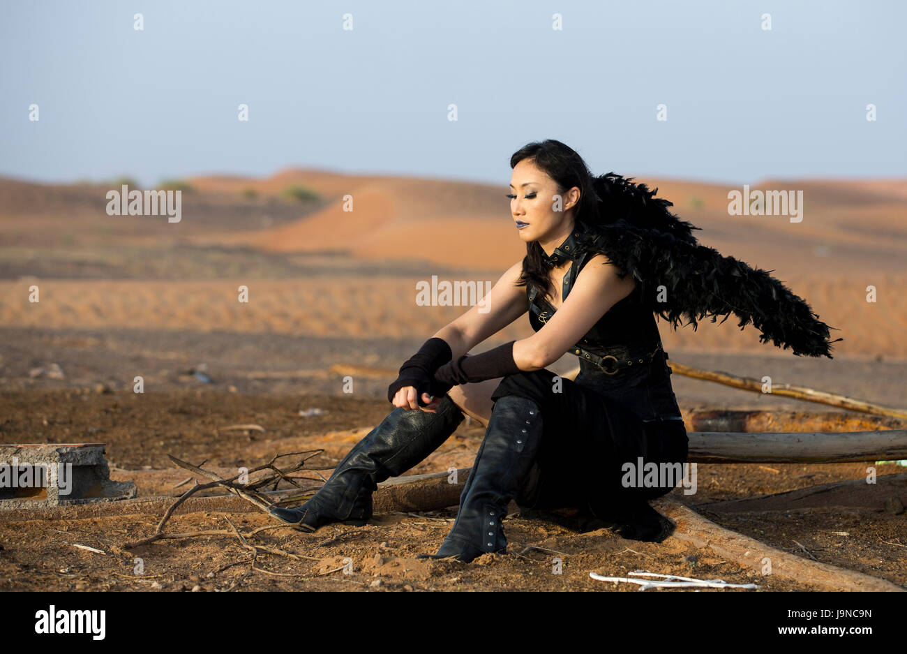 Giovane donna con black angel wings in un deserto vicino a Dubai Foto Stock