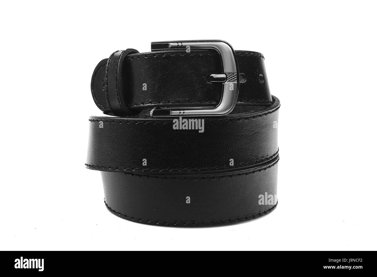 Cinghia in pelle maschile.L'accessorio alla moda è attorcigliato su sfondo bianco.con una fibbia in metallo.naturale pelle animale. Foto Stock
