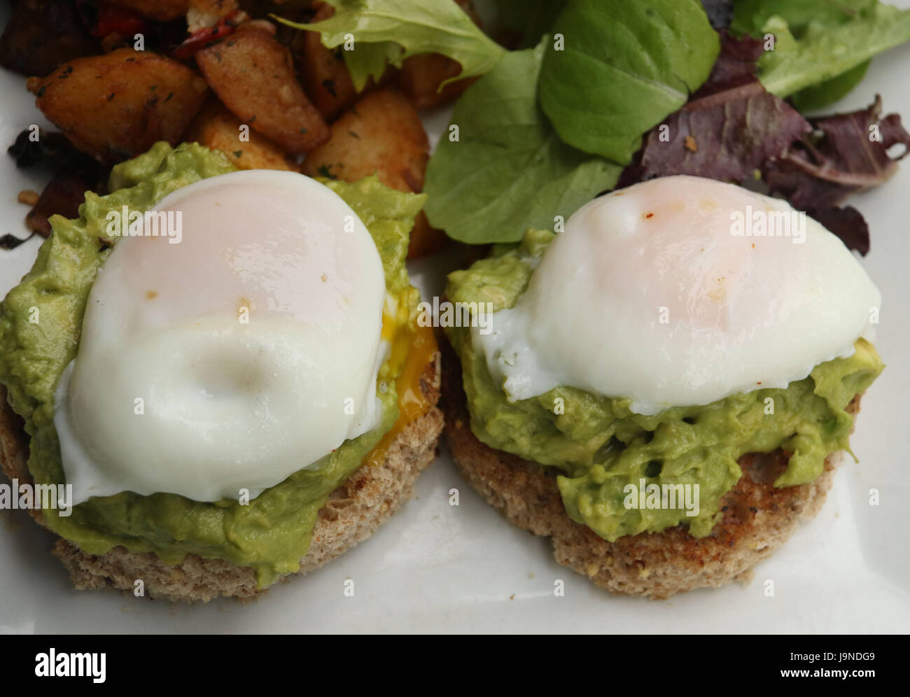 Le uova in camicia su toast avocado Foto Stock