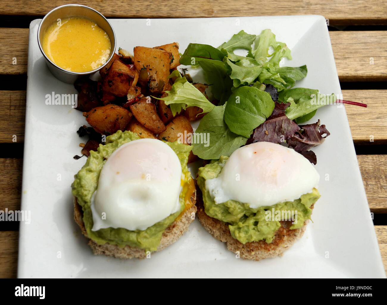 Uovo affogato con avocado spalmata sul pane tostato multigrain Foto Stock