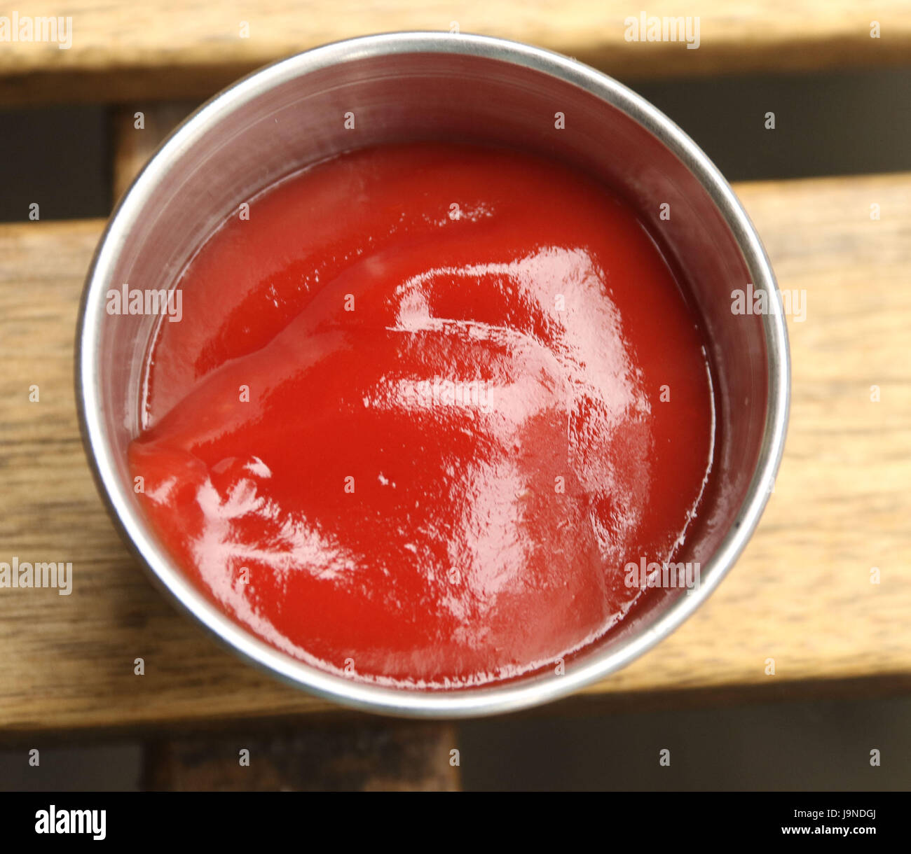 Ketchup nel round silver contenitore sul tavolo da picnic Foto Stock