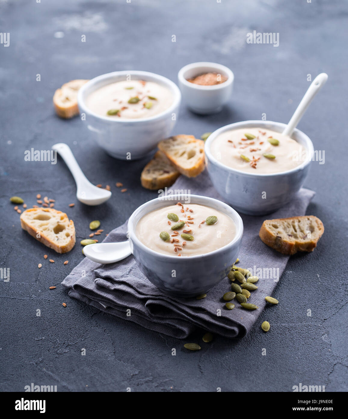 Il cavolfiore Zuppa servita con semi di zucca e pane di grano Foto Stock
