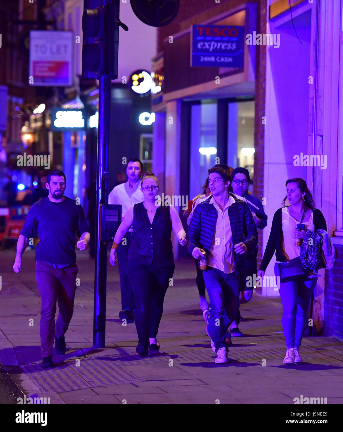 La gente corre lungo Borough High Street mentre la polizia si sta occupando di un 'incidente principale' al London Bridge. Foto Stock