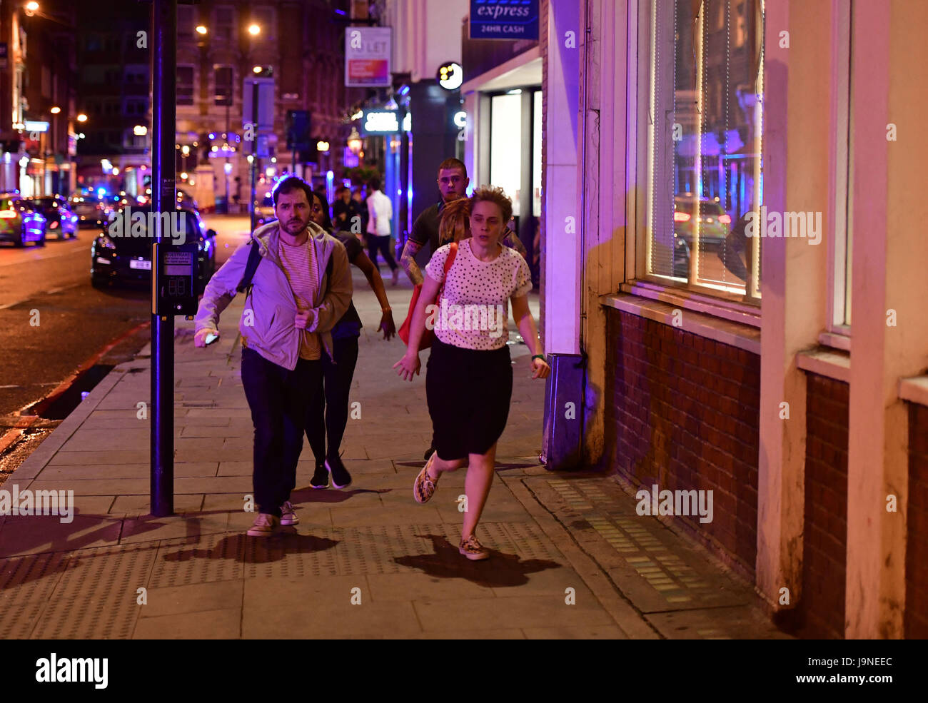 La gente corre lungo Borough High Street mentre la polizia si sta occupando di un 'incidente principale' al London Bridge. Foto Stock