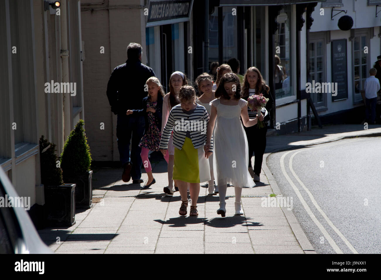 Giovani damigelle posies portante e con gli amici a piedi in strada Foto Stock