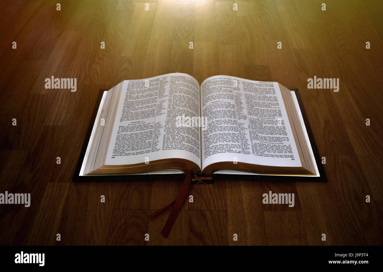 Aprire la Bibbia su uno sfondo di legno con candelette Foto Stock