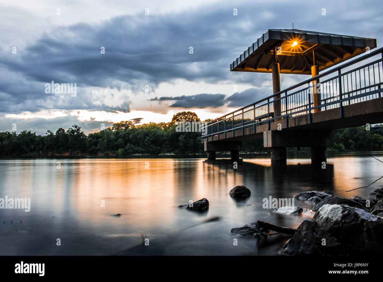 Il molo sul fiume Nuvoloso Tramonto lunga esposizione Foto Stock