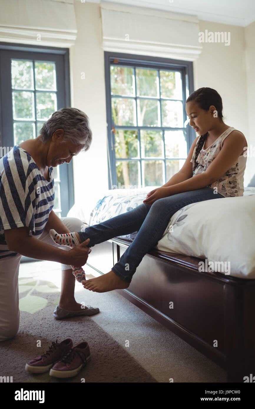 Nonna aiutando la nipote di indossare calze in camera da letto a casa Foto  stock - Alamy
