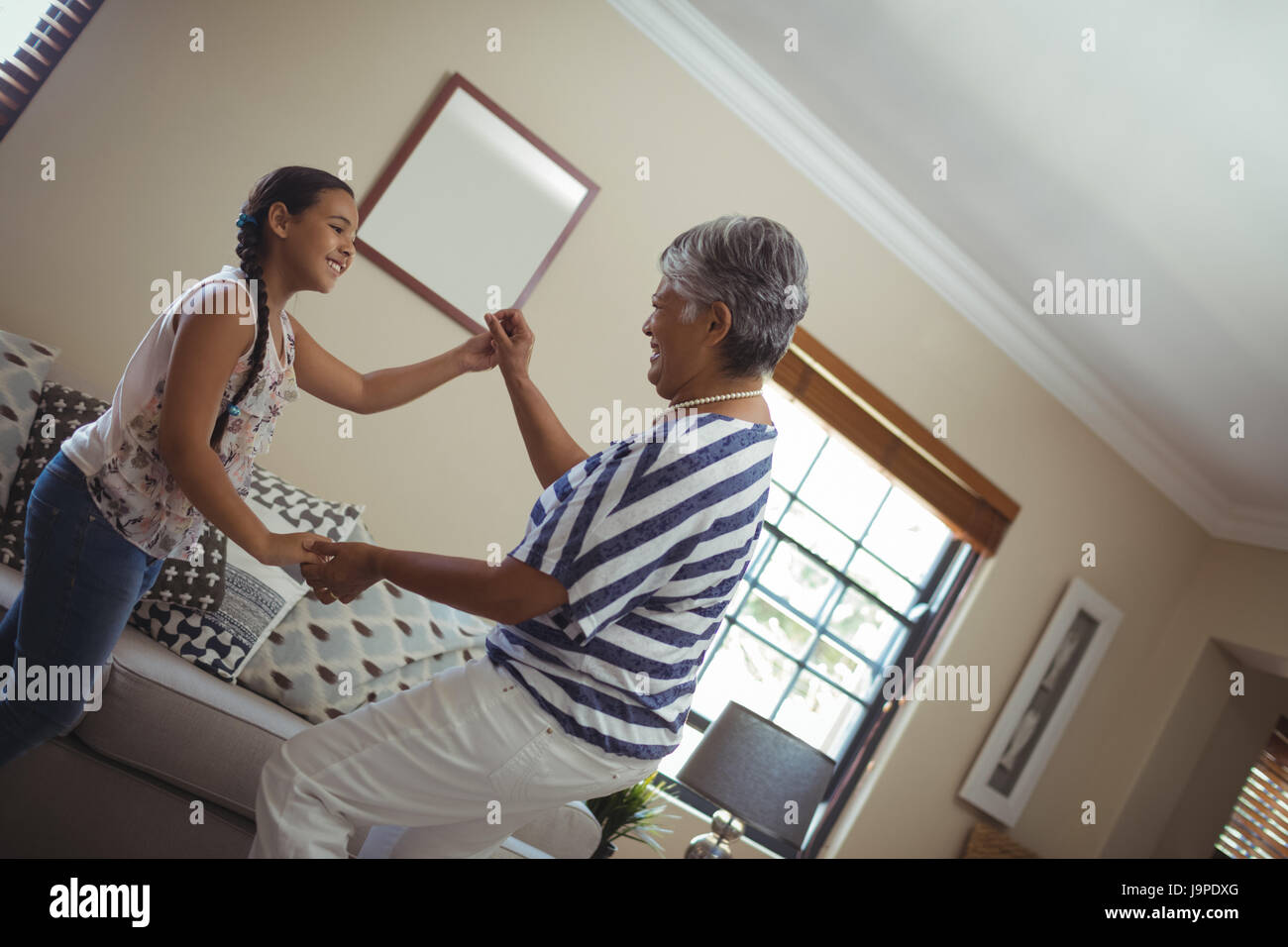 Nonna e nipote divertendosi nel salotto di casa Foto Stock