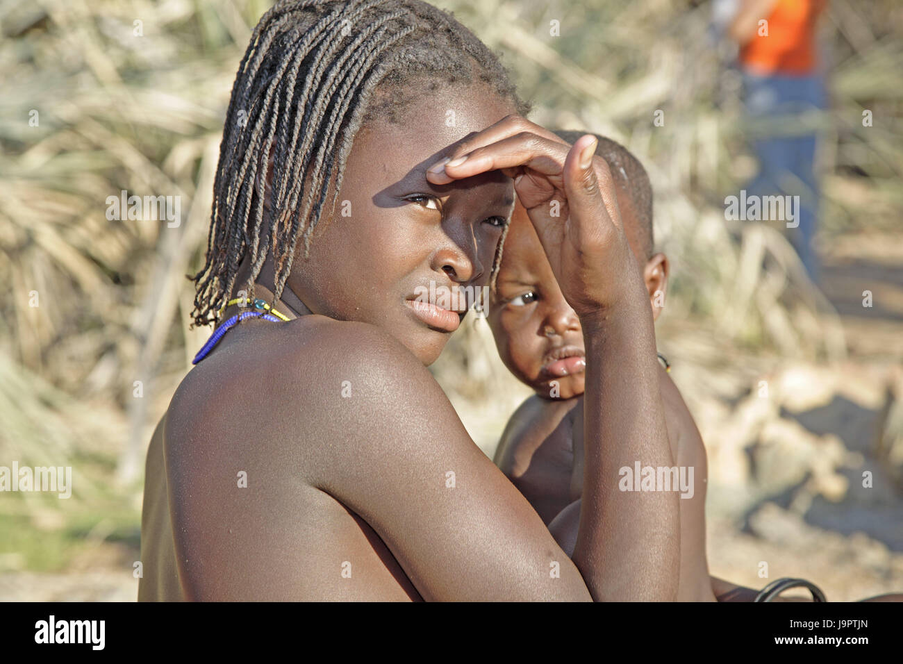 La Namibia,Kaokoveld,Himba girl,baby,gesto,sun,fade out,ritratto,l'Africa,persona,africani, non bianchi,ragazze,seriamente,child,ceppo Himba,mezza nomad,Himba,tribù,infante,giovani persone,le trecce,il colore della pelle, Foto Stock