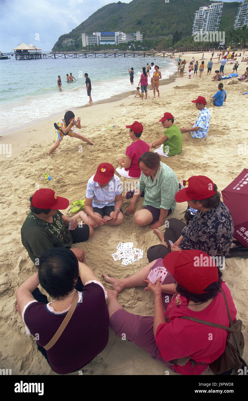 Cina,Hainan Islanda,Sanya,Dadonghai Beach,tourist,giochi di carte,Asia,Asia Orientale,destinazione,beach,spiaggia sabbiosa,Persone,vacanziere,Vacanza,riposo,vacanza in spiaggia,all'esterno,mare,bagnanti,disegnato,abiti,SCHEDE,gioco,gioco,prendere foto, Foto Stock