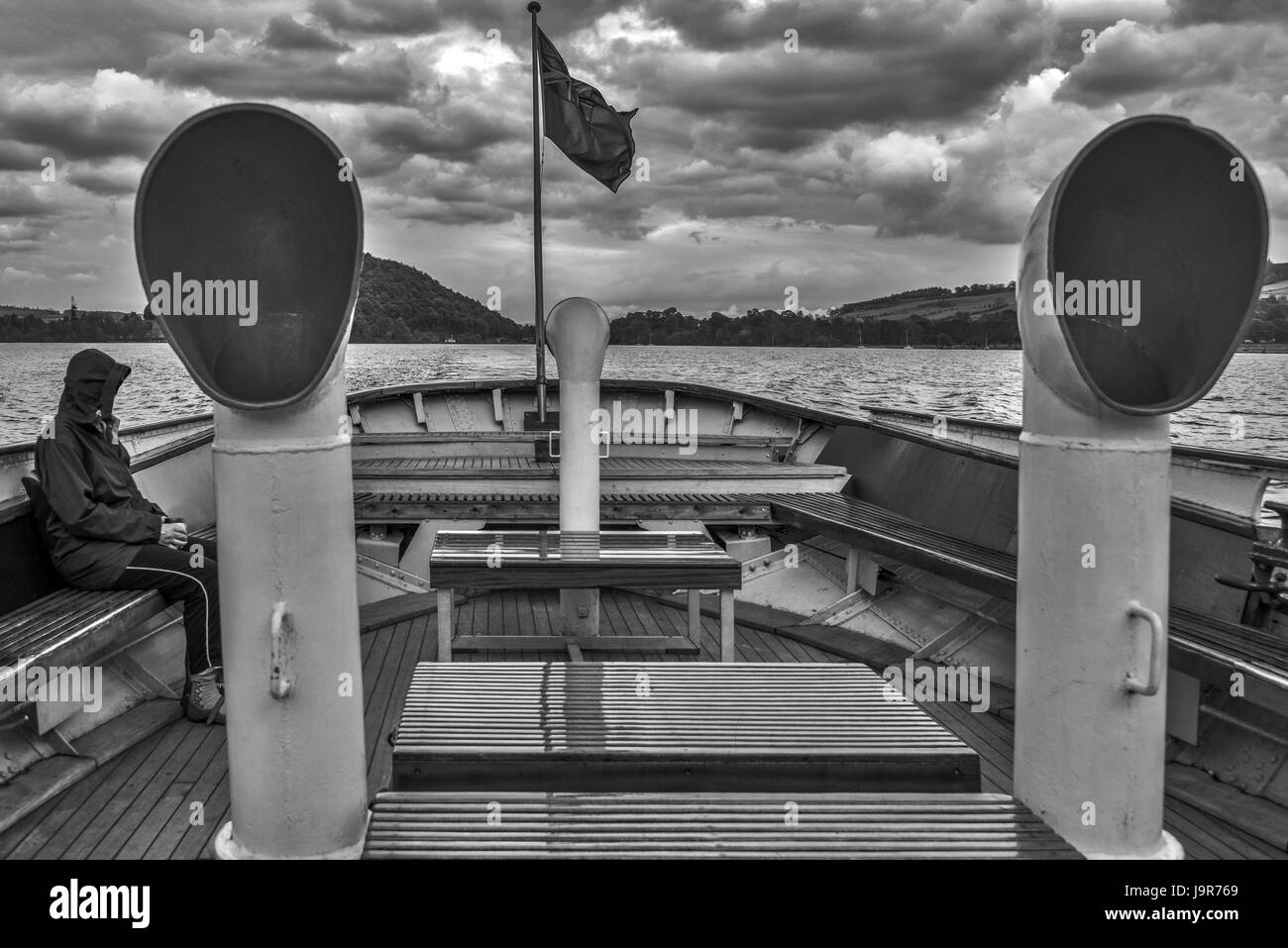 Mono immagine di una donna che indossa un clima umido corona, in un lago di traghetto, Ullswater, Lake District, REGNO UNITO Foto Stock