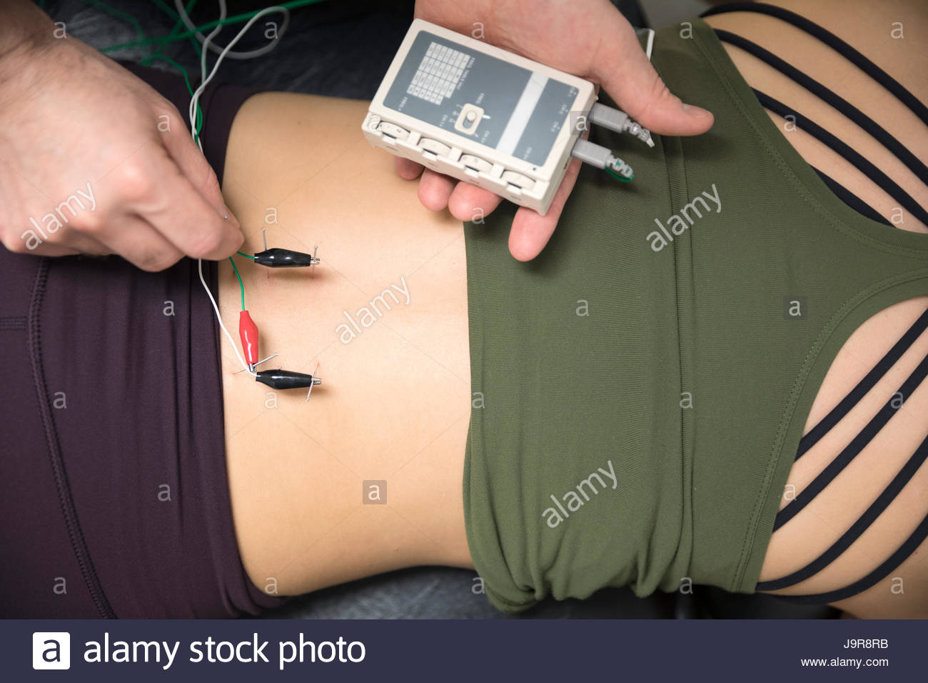 Agopuntore immissione aghi elettrici nel retro del client femmina Foto Stock