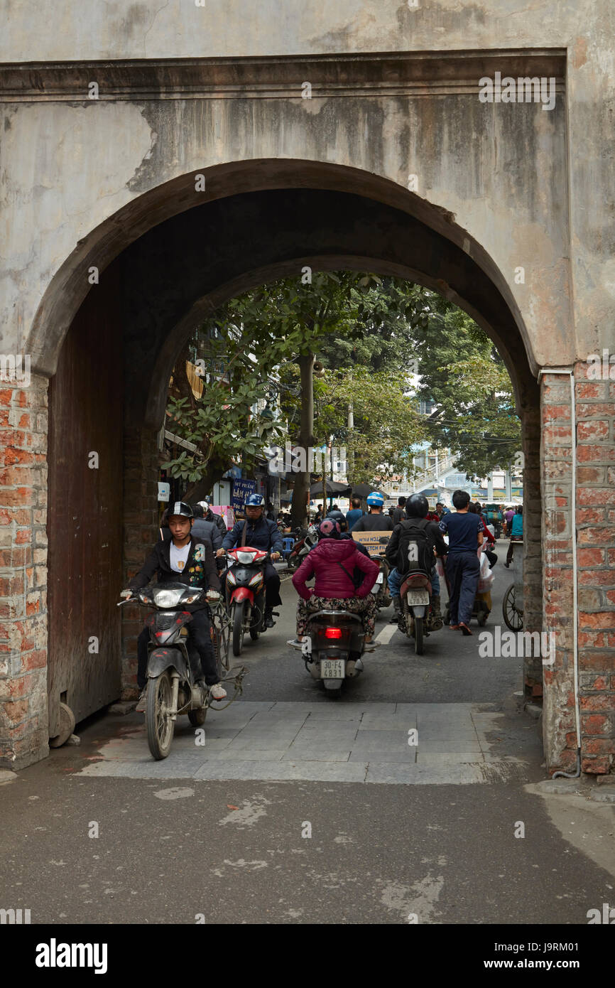 Moto passando attraverso la storica Quan Chuong gate verso il quartiere vecchio, Hanoi, Vietnam Foto Stock