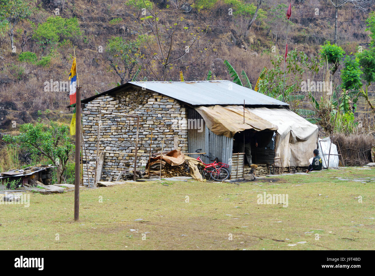 Casa Piccola con pareti in pietra e metallo ondulato tetto, Ngadi Bazar, regione di Annapurna, Nepal. Foto Stock