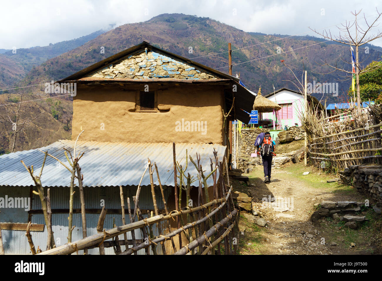 Trekker attraversando il villaggio di Bahundanda, Lamjung distretto, Nepal. Foto Stock