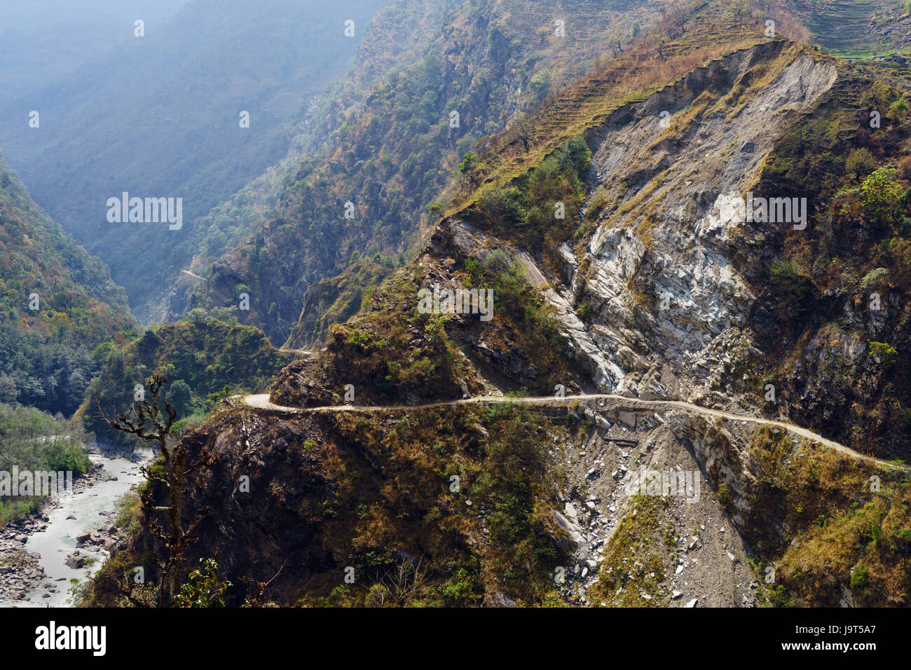Strada pericolosa scolpito in una scogliera, che conduce lungo la parte superiore della valle marsyangdi, Nepal. Foto Stock