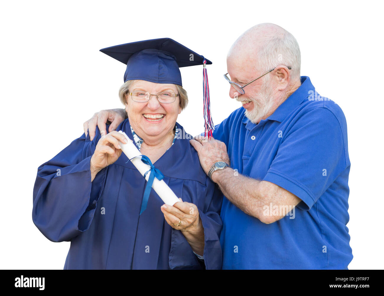 Senior donna adulta laureato nel cappuccio e camice essendo congratulato da marito isolato su bianco. Foto Stock