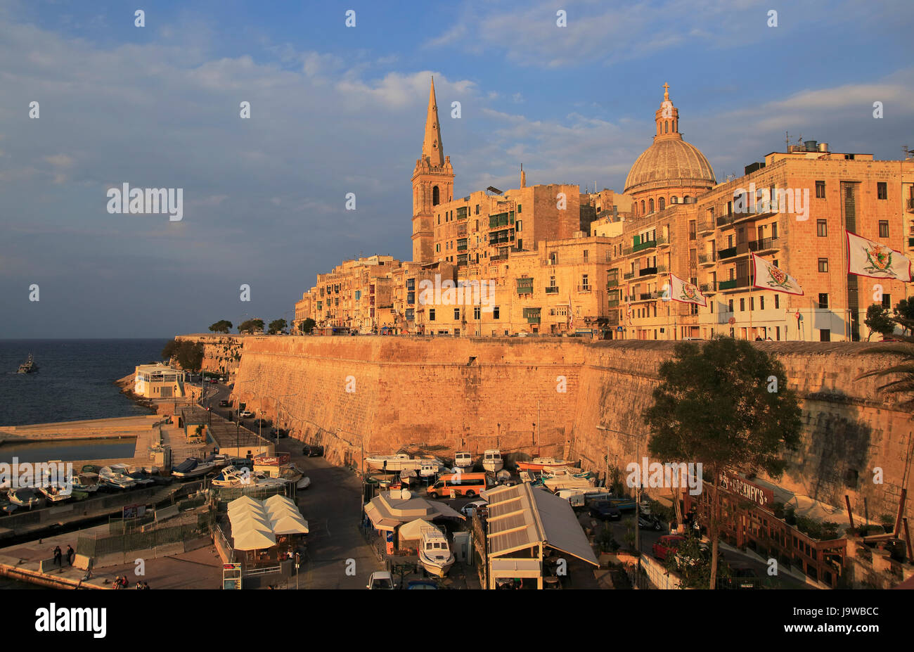 Golden calda luce della sera su edifici e chiese La Valletta, Malta, cupola Basilica di Nostra Signora del Monte Carmelo chiesa Foto Stock