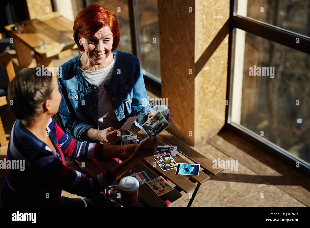 Donna anziana che mostra le foto dei suoi nipoti per amico Foto Stock