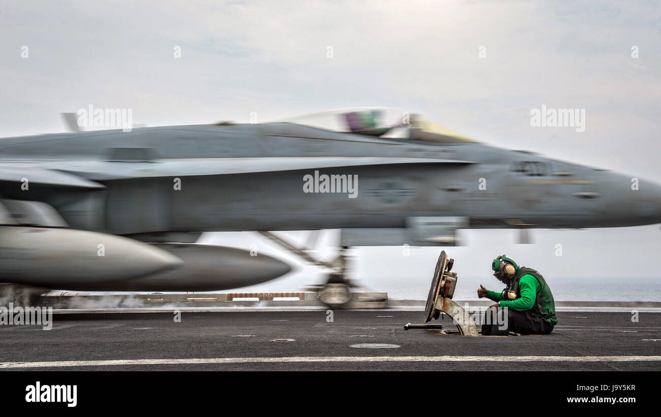 U.S. marinai direct aerei di atterraggio sul ponte di volo a bordo della USN Nimitz-class portaerei USS Carl Vinson Maggio 23, 2017 nell'Oceano Pacifico. (Foto di Rebecca Sunderland /US Navy via Planetpix) Foto Stock
