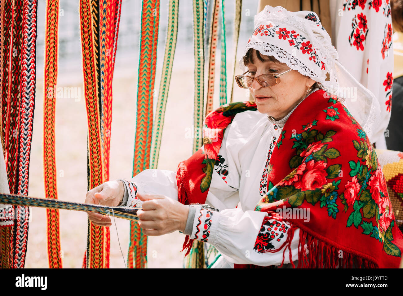 Gomel, Bielorussia - Settembre 12, 2015: Donna in nazionale bielorussa costume folk cinghia di tessitura Foto Stock