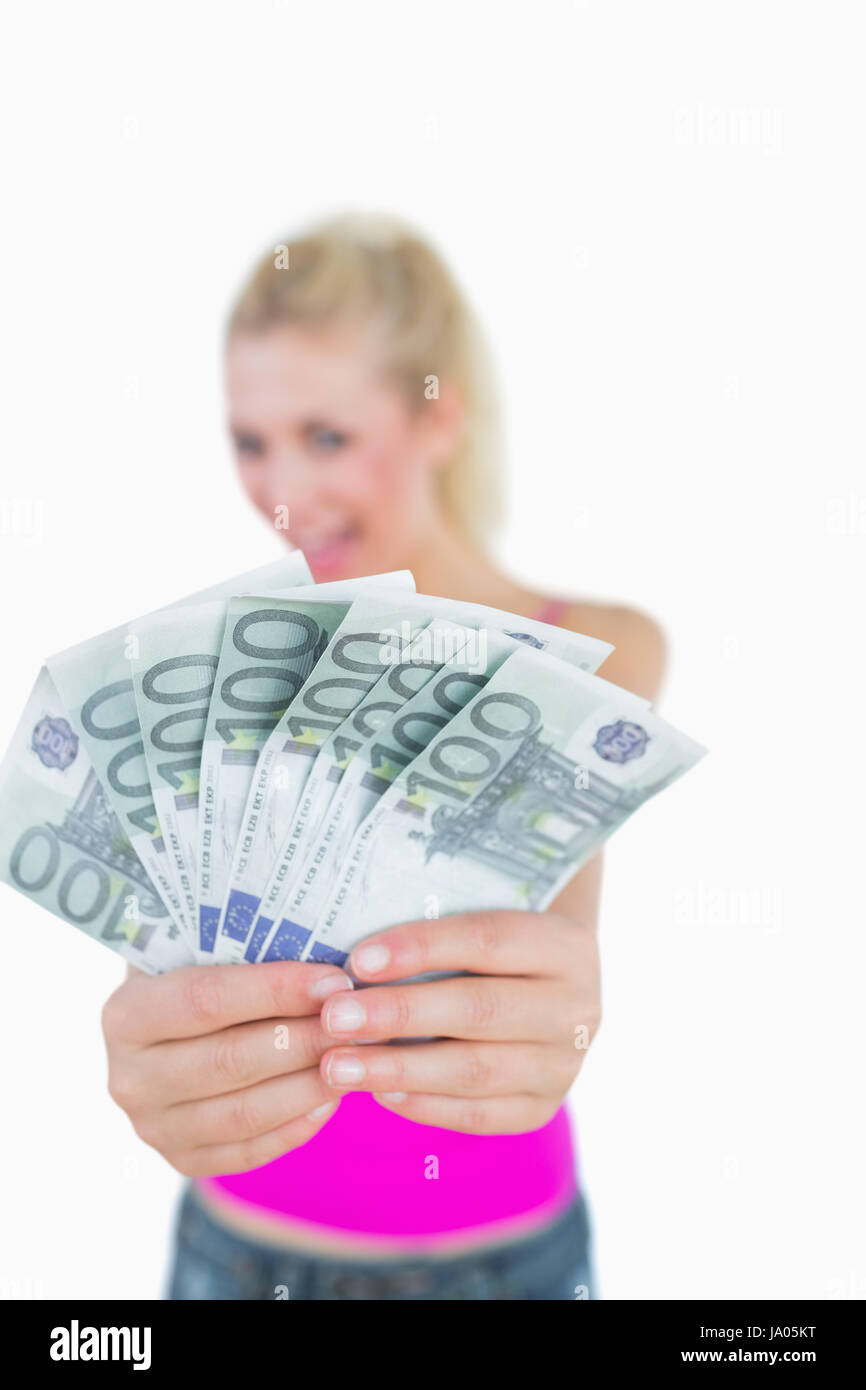 Giovane donna tenendo fuori aperti a ventaglio delle banconote in euro su sfondo bianco Foto Stock
