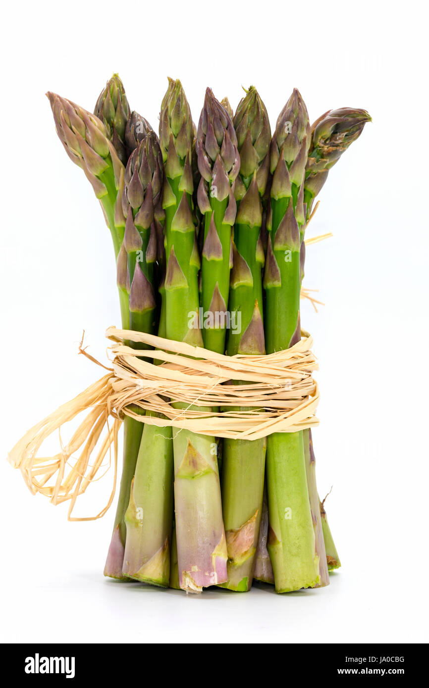 Mazzetto di freschi Asparagi verdi spears legato con rafia close-up isolato su bianco. Foto Stock