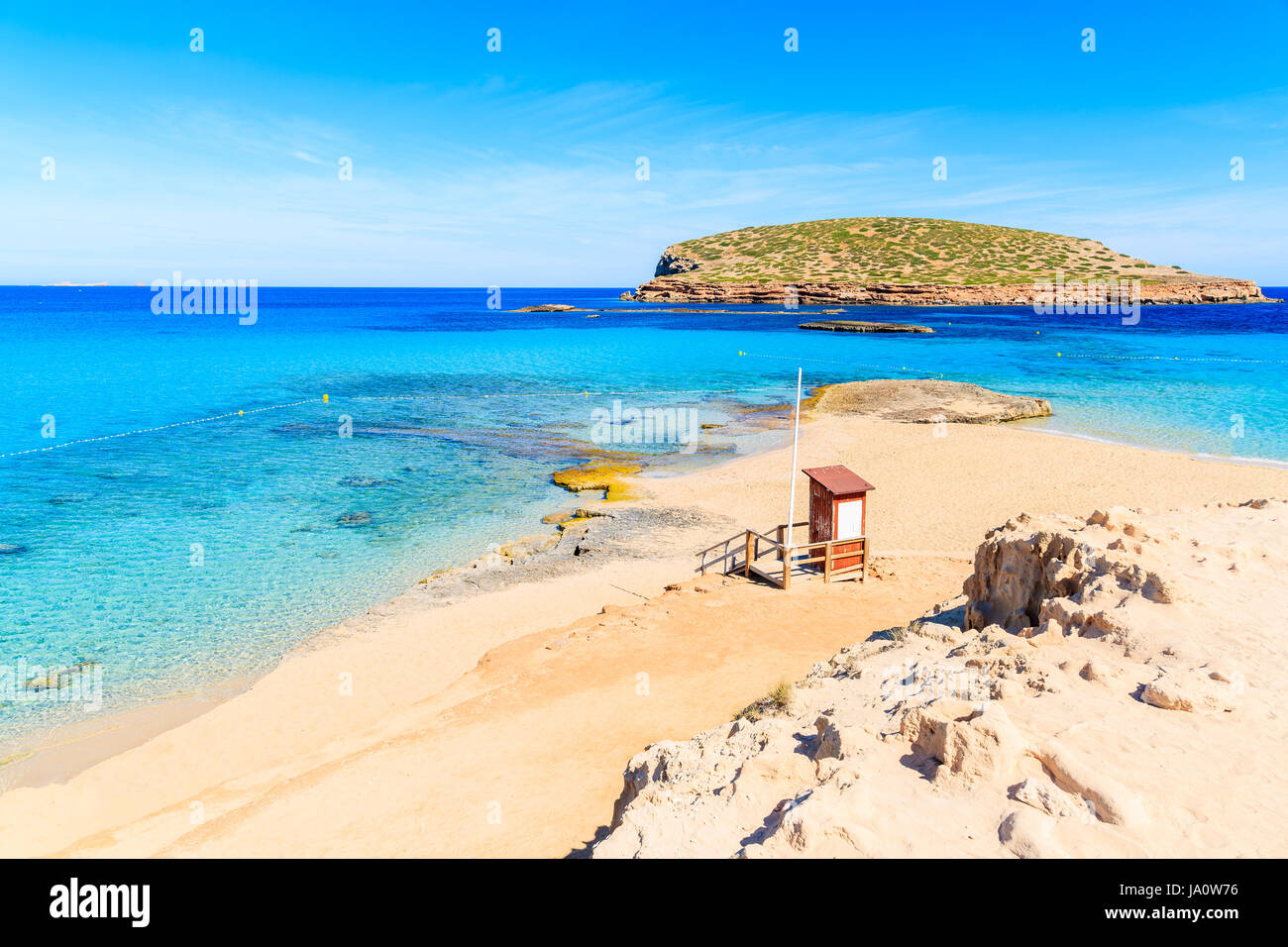 Bagnino torre sulla bellissima Cala Comte spiaggia famosa per il suo azzurro cristallino mare poco profondo acqua, isola di Ibiza, Spagna Foto Stock