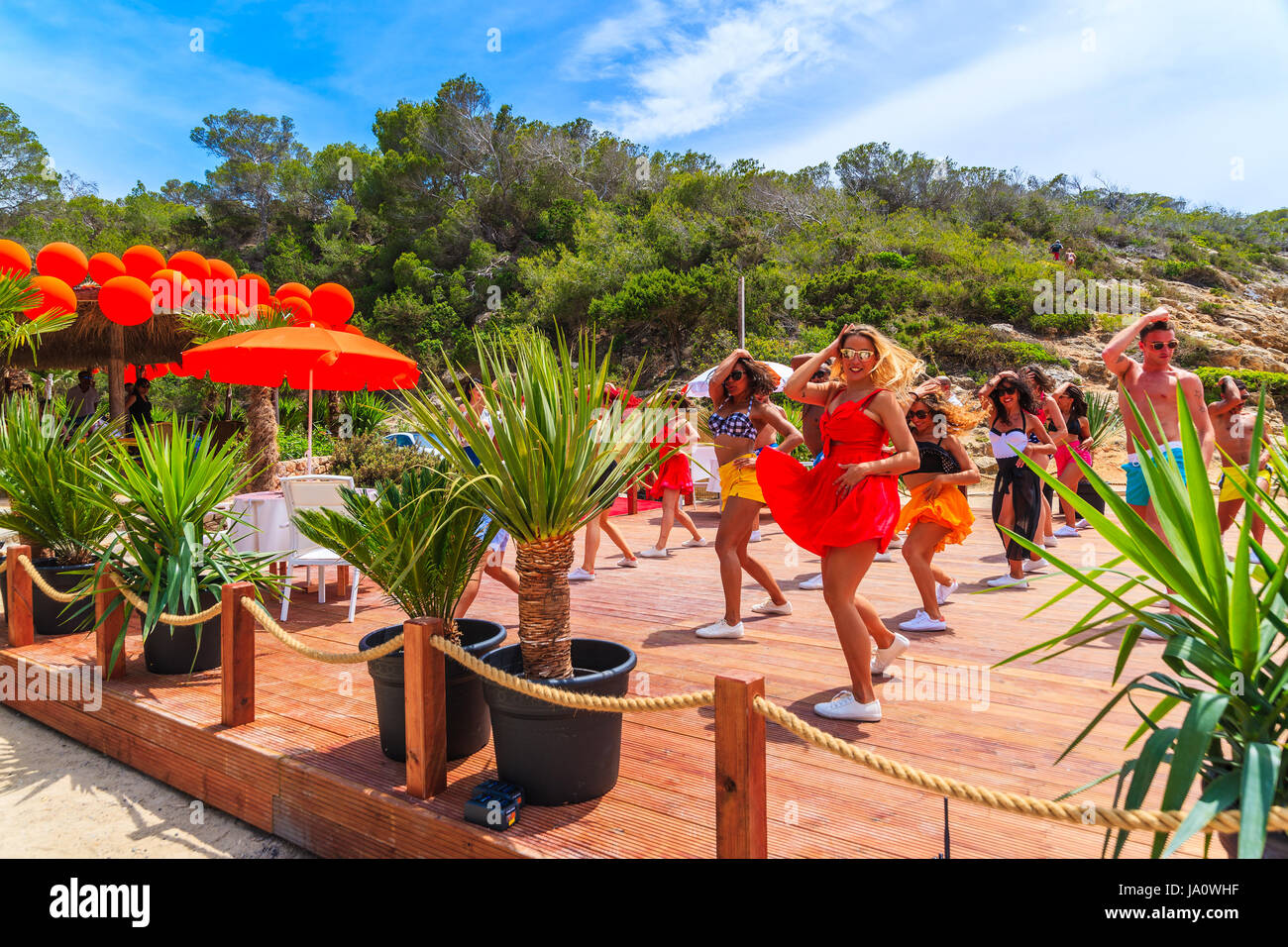 Isola di Ibiza, Spagna - 17 Maggio 2017: i giovani ballare sulla terrazza del ristorante sulla spiaggia di Cala Carbo mentre vengono ripresi in modo da produrre Foto Stock