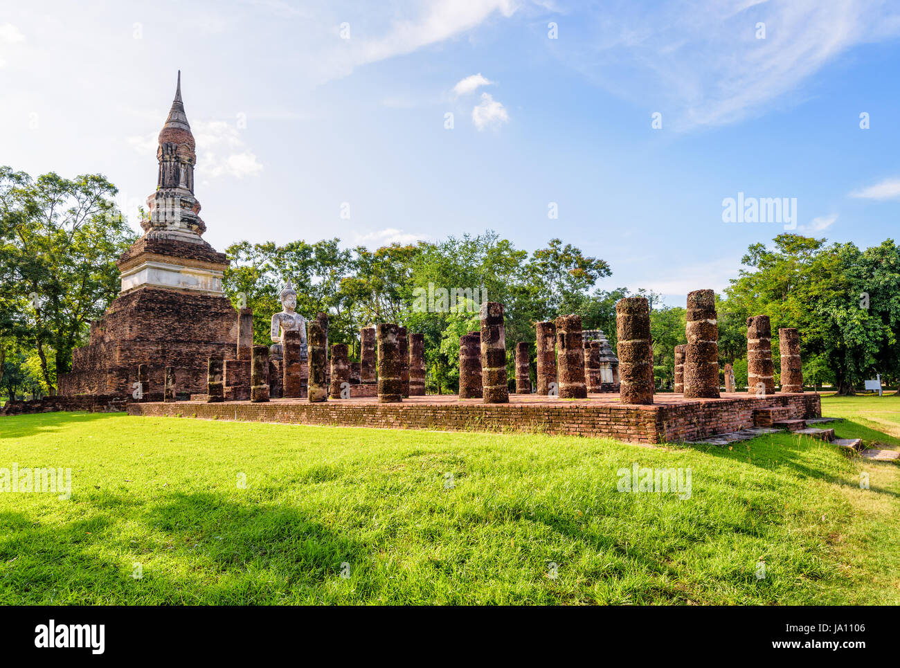 Antica cappella pagoda statua del Buddha tra i ruderi di pilastri di Wat Traphang Ngoen tempio attrazione turistica famosa religiosa landmark al Sukhothai il suo Foto Stock