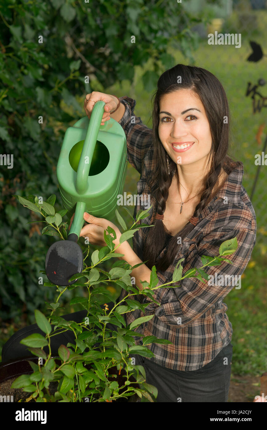 La donna si prende cura dei suoi impianti di irrigazione con cautela le piantine Foto Stock
