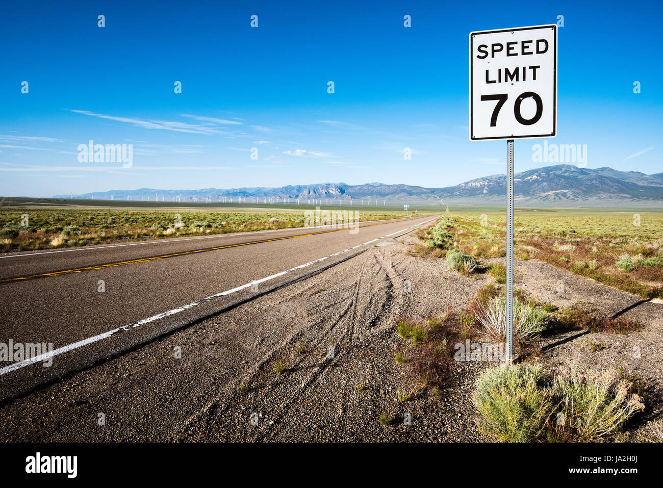 Una autostrada avvicinando la valle di primavera Wind Farm, vicino a Ely, Nevada e il Parco nazionale Great Basin. Foto Stock