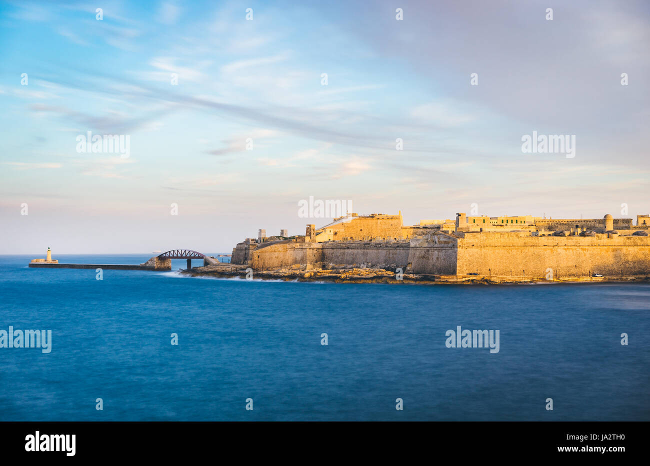 Il Forte Sant'Elmo e frangiflutti con il faro al tramonto, Valletta, Malta Foto Stock