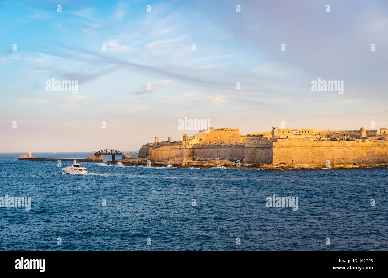 Il Forte Sant'Elmo e frangiflutti con il faro al tramonto, Valletta, Malta Foto Stock