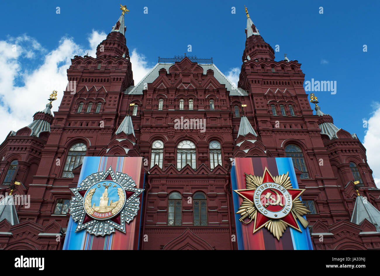 Le decorazioni per il 1 maggio sfilano sulla facciata del museo storico statale, la storia russa museo in un iconico del XIX secolo edificio rosso Foto Stock
