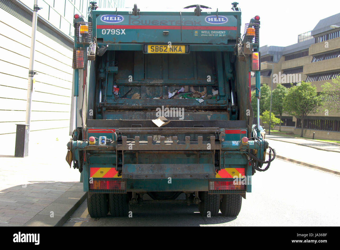Gli uomini lo scomparto di raccolta dei rifiuti rimozione rifiuti autocarro Foto Stock