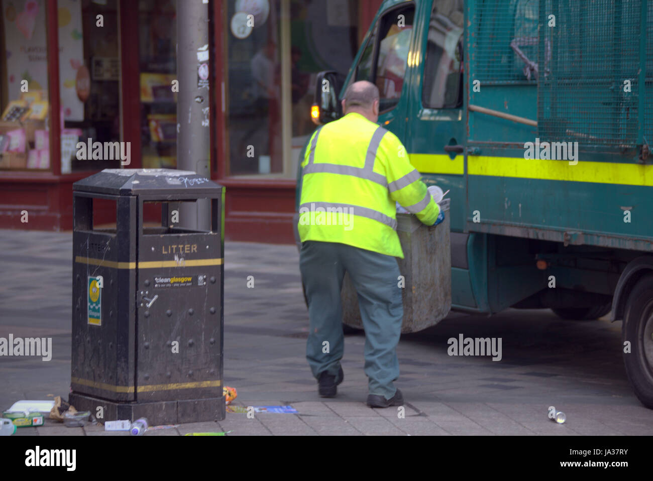 Gli uomini lo scomparto di raccolta dei rifiuti rimozione rifiuti autocarro Foto Stock