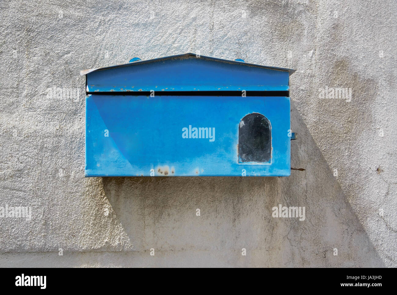 Cassetta postale blu anteriore del vecchio muro di cemento di casa Foto Stock