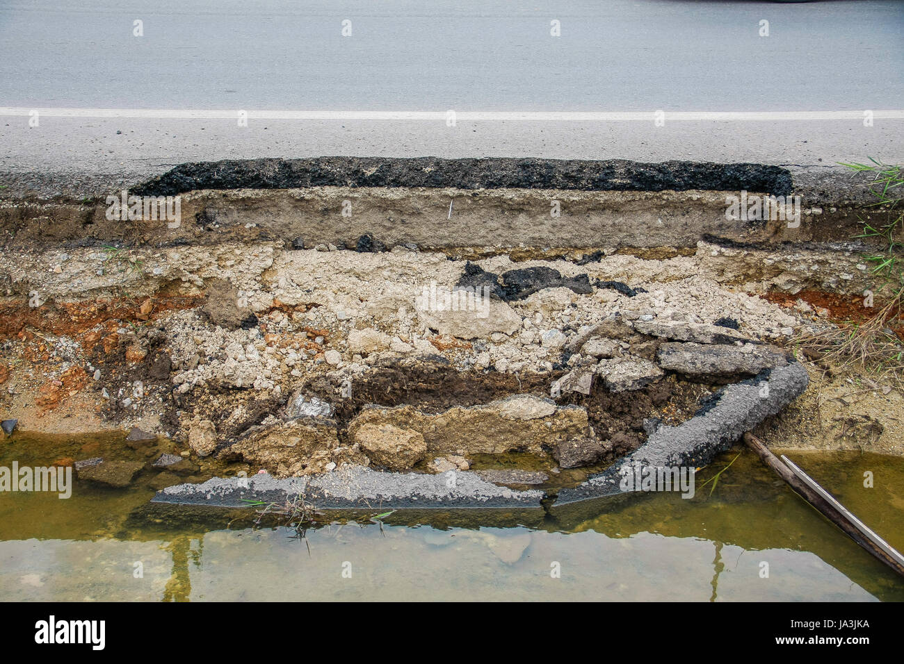 Rottura dello strato di asfalto road con acqua Foto Stock